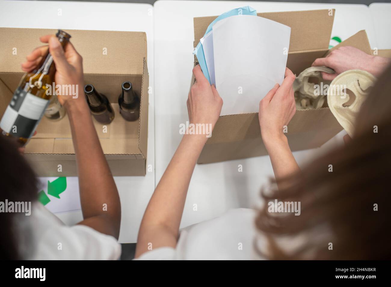 Primo piano su immagine delle mani delle ragazze che ordinano il roba in scatole Foto Stock