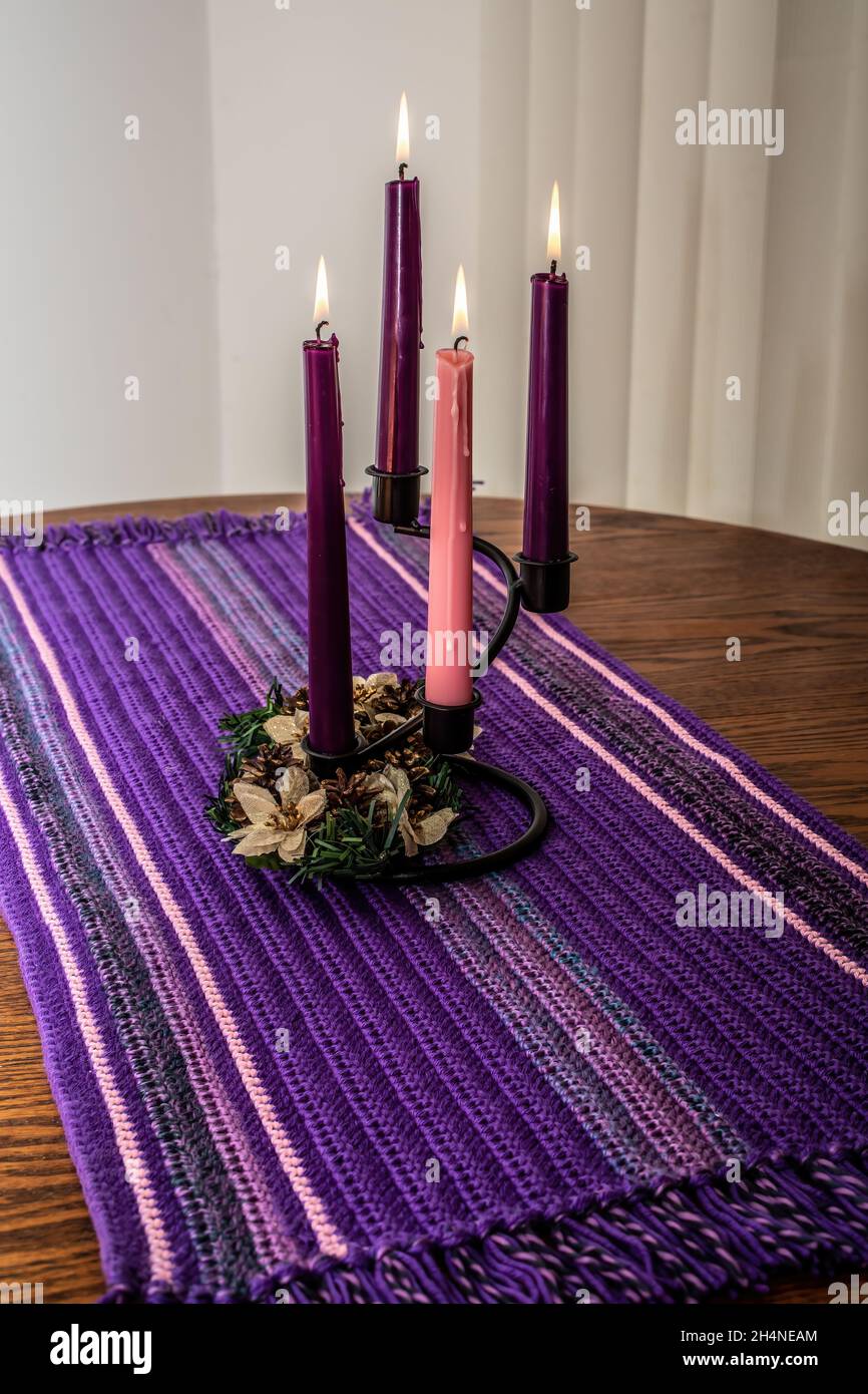 Le candele dell'avvento con una corona di fiori su un corridore casalingo della tabella uncheted. Foto Stock