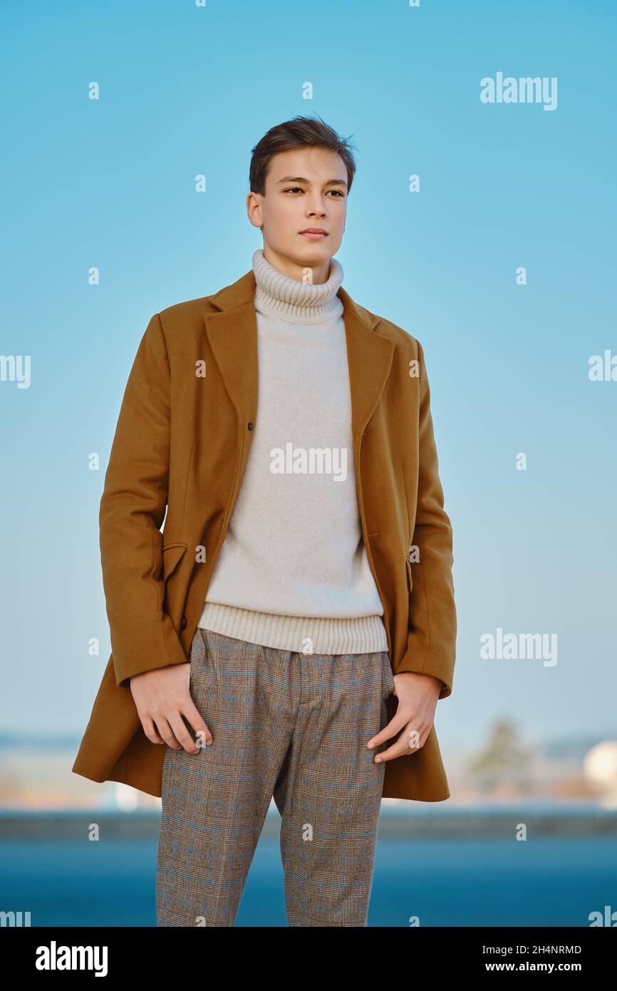 Abbigliamento primavera - autunno. Street fashion. Giovane uomo in  pantaloni a scacchi, maglione e cappotto di lana Foto stock - Alamy