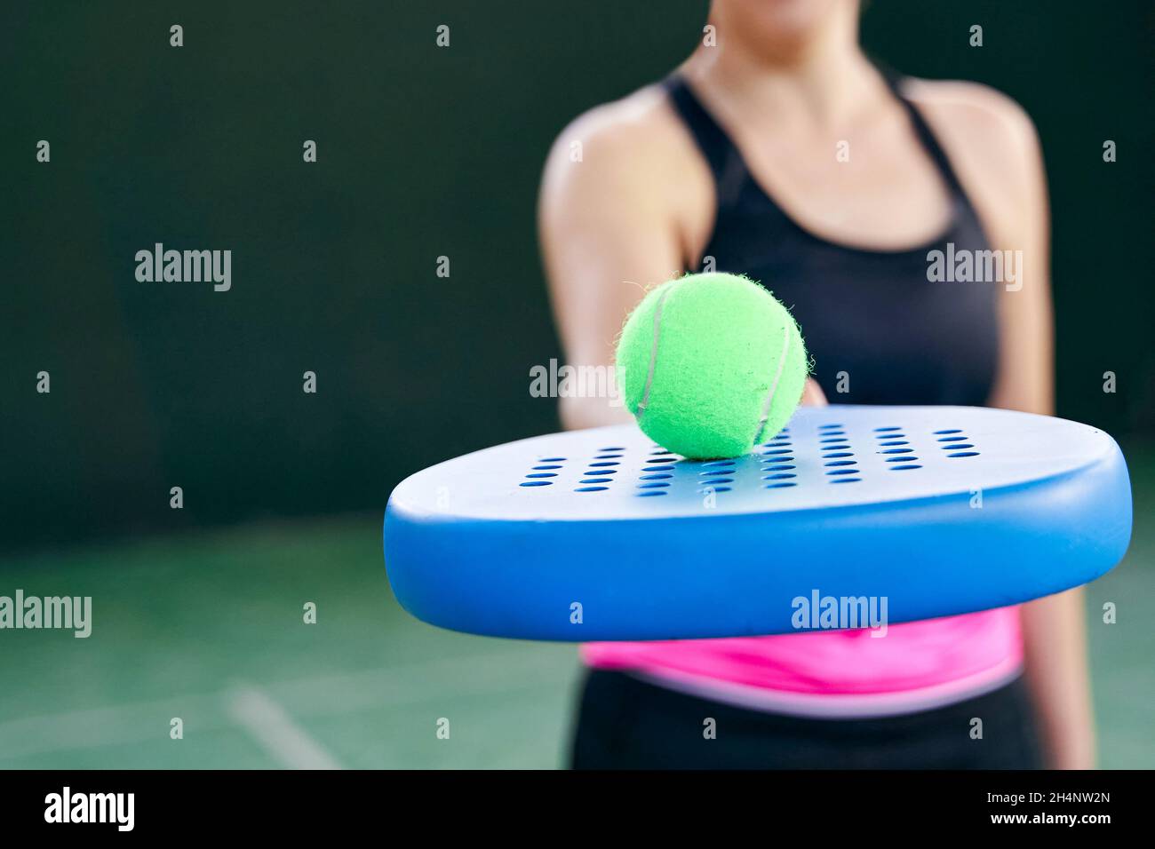 Atleta con racchetta e pallina di padel sul campo, primo piano. Foto di alta qualità Foto Stock