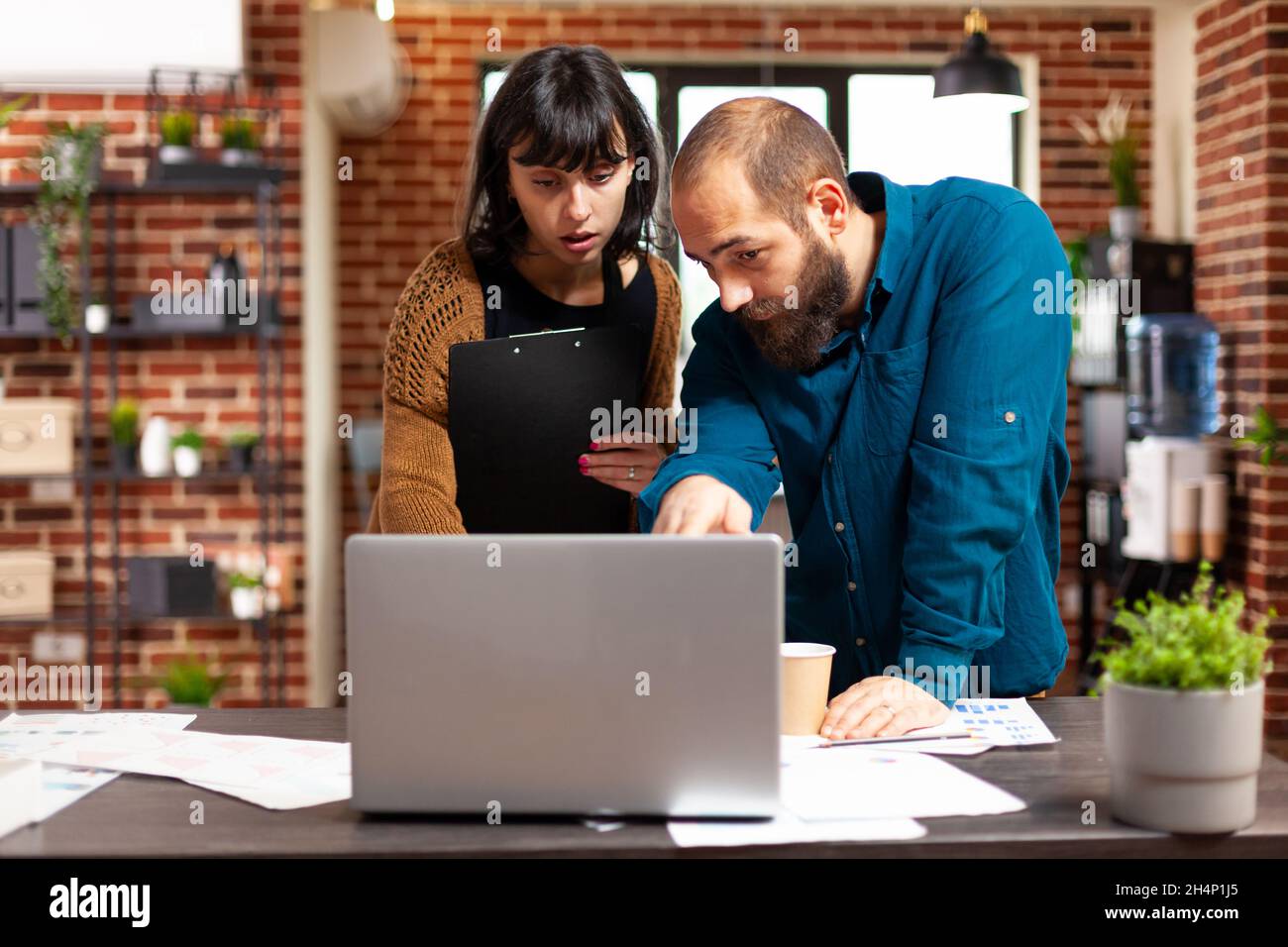 Team di comunicazione che esamina la strategia di gestione utilizzando un laptop che analizza le idee aziendali relative al brainstorming della documentazione aziendale. Businesspeople che lavorano alla riunione finanziaria di vendita di pianificazione di progetto Foto Stock