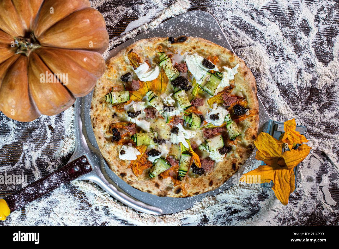 Pizza italiana con fiori di zucchine, zucchine, mozzarella e tartufo Foto Stock