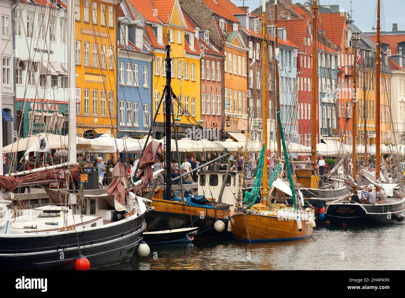 Nyhavn è un litorale, un canale e un quartiere di intrattenimento del secolo scorso a Copenhagen, Danimarca. Fiancheggiato da colori vivaci 17 ° e inizio 18 ° C. Foto Stock