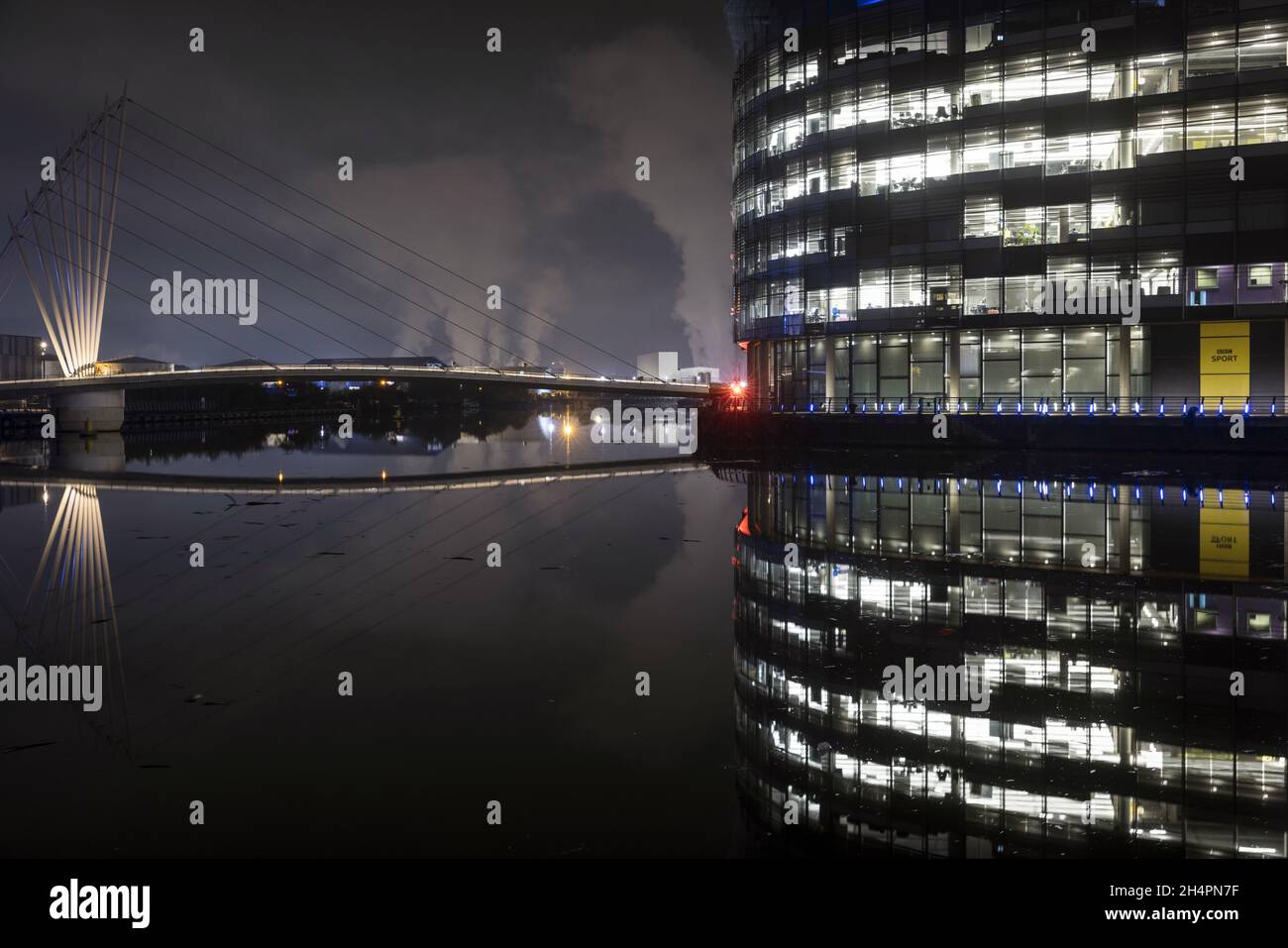 Edifici di Media City e un ponte sul canale della nave di Manchester a Salford Quays, di notte Foto Stock