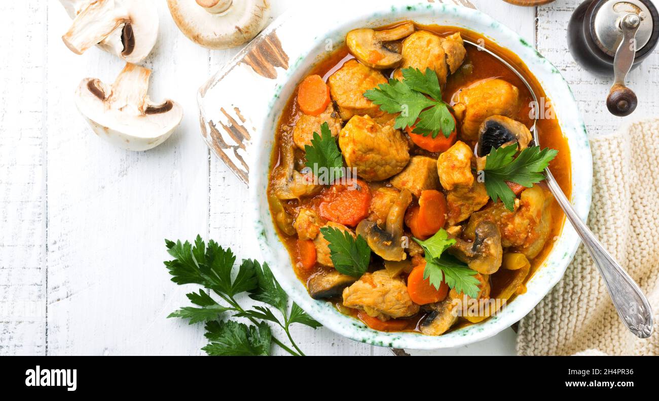 Goulash di manzo. Stufato di carne con verdure e funghi con vino rosso, piatto tradizionale della cucina francese. Vista dall'alto con spazio di copia. Foto Stock