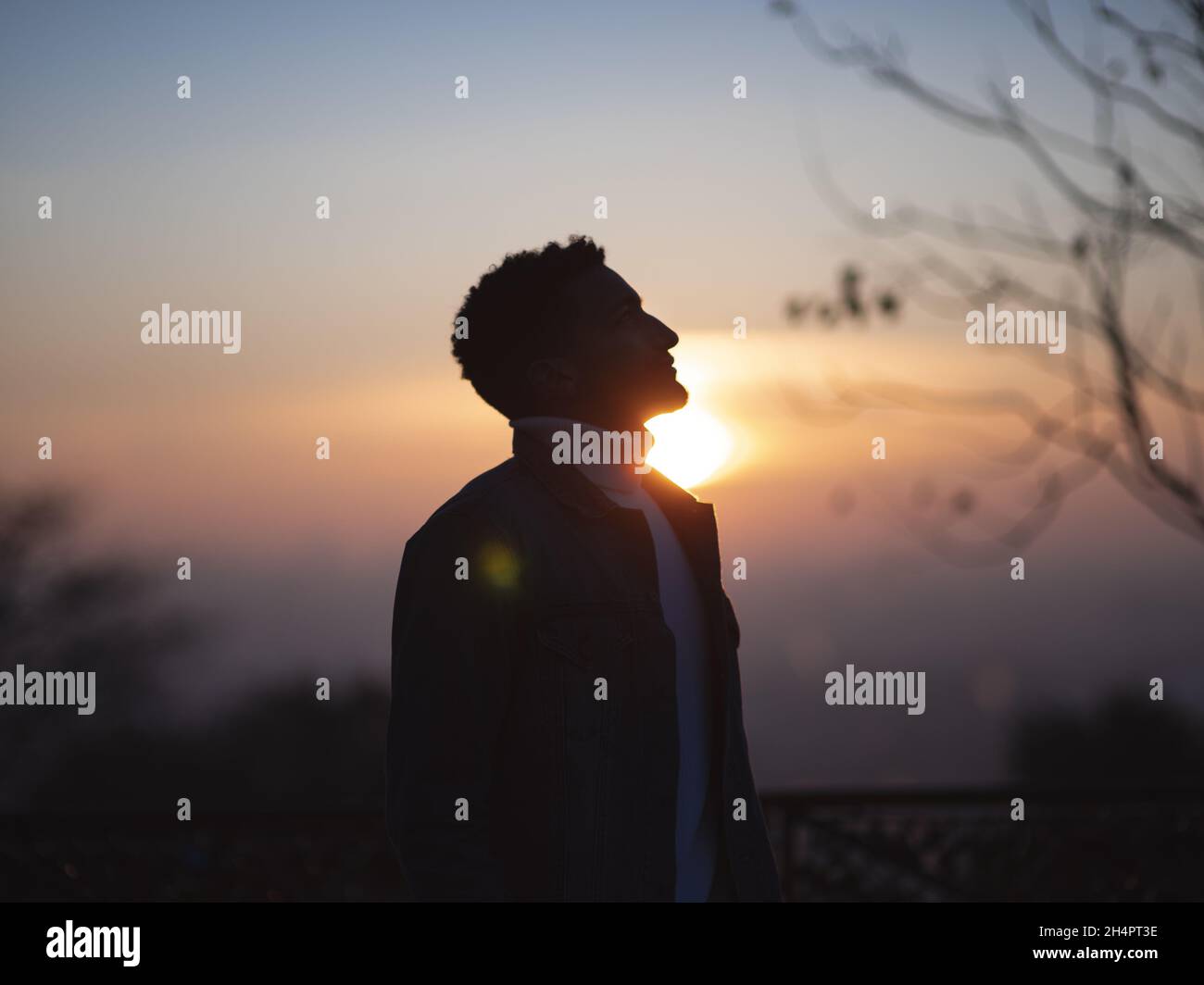 PARIGI, FRANCIA - 02 gennaio 2021: Una silhouette da primo piano di un ragazzo a Montmartre con vista di un bellissimo tramonto Foto Stock