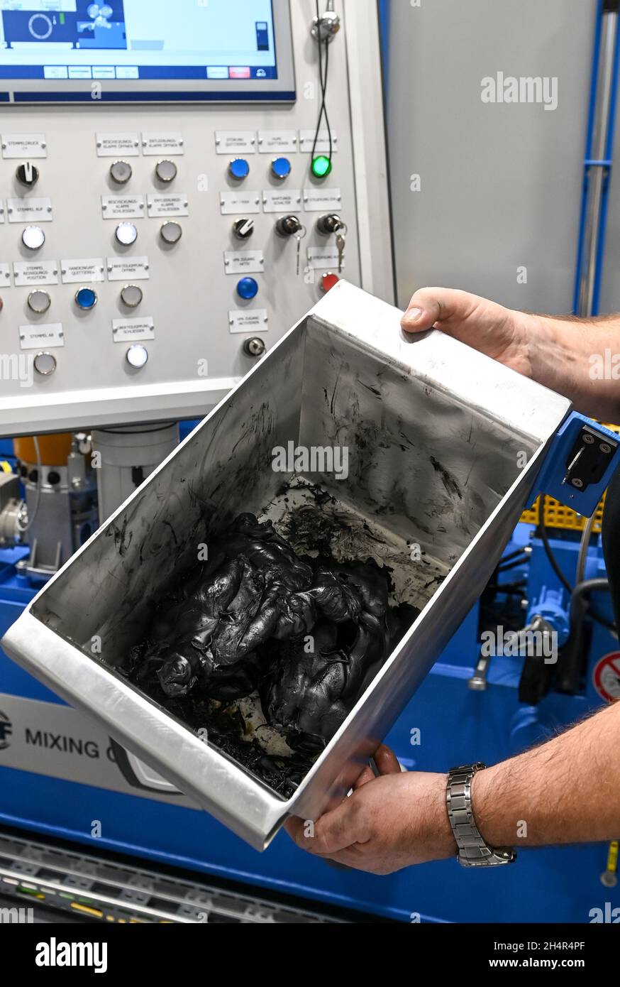 Schkopau, Germania. 4 novembre 2021. Un dipendente del Fraunhofer Pilot Plant Center for Polymer Synthesis and Processing PAZ di Schkopau detiene il composto finito in mano in un impianto di compounding del nuovo centro tecnico. L'edificio di ampliamento è stato aperto ufficialmente. Nel settore della lavorazione dei polimeri sono stati investiti complessivamente dieci milioni di euro. Credit: Hendrik Schmidt/dpa-Zentralbild/ZB/dpa/Alamy Live News Foto Stock