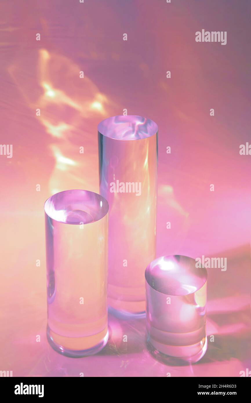 tre podi in vetro chiaro su sfondo rosa pastello Foto Stock