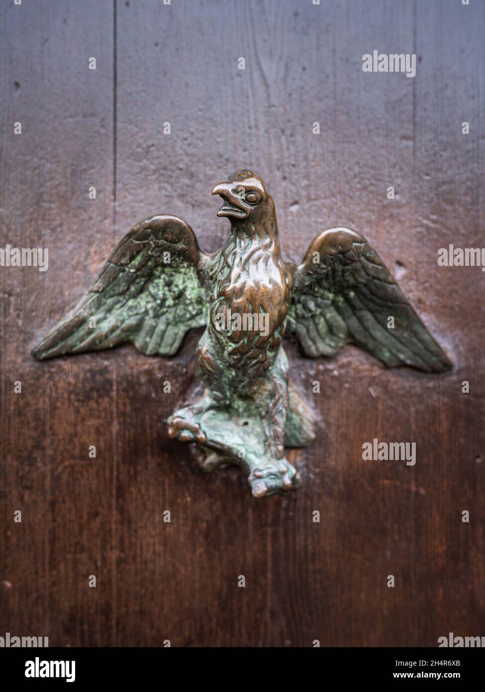 Primo piano di una maniglia in bronzo su una porta marrone a Venezia (Italia), a forma di uccello Foto Stock