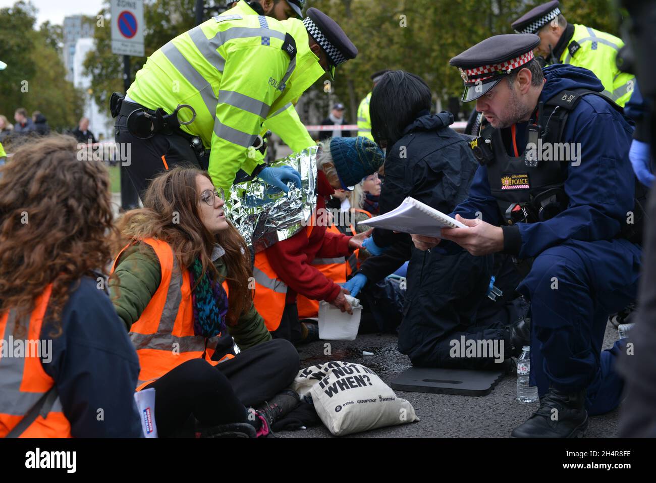 Londra, Regno Unito. 4 novembre 2021. La polizia fa un arresto durante la protesta. Isolare gli attivisti britannici bloccano le strade intorno al Parlamento incollandosi sulle strade. Credit: Thomas Krych/Alamy Live News Foto Stock