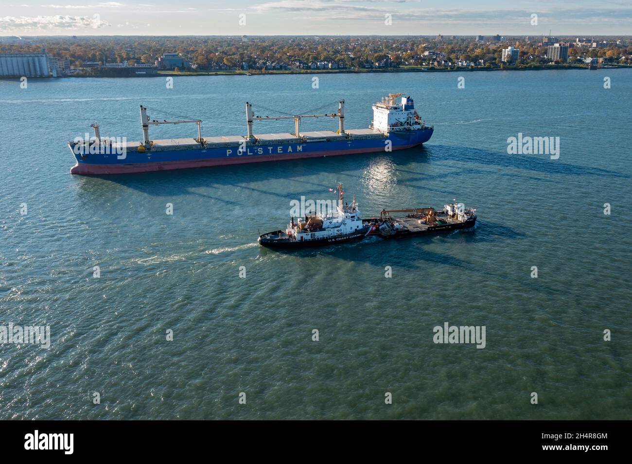 Detroit, Michigan - Una nave della Guardia Costiera degli Stati Uniti, che spinge una chiatta, passa la Lubie, una nave oceanica ancorata nel fiume Detroit. Il Lubie, di proprietà di Foto Stock