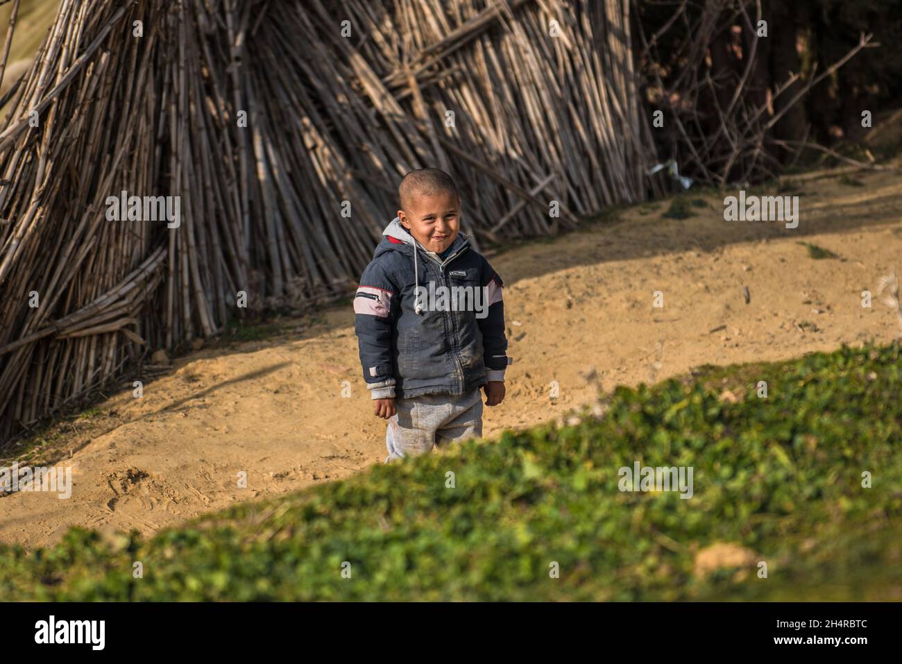 Un bambino rifugiato che guarda la macchina fotografica con un sorriso Foto Stock
