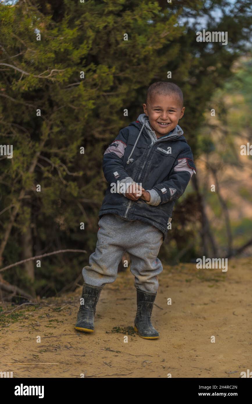 Un bambino rifugiato che guarda la macchina fotografica con un sorriso Foto Stock