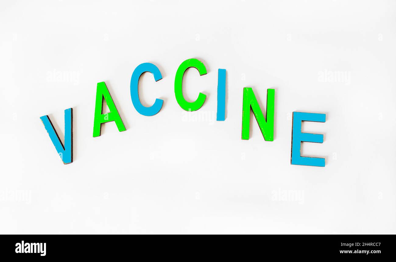 La parola VACCINO è scritta su lettere di legno colorate, su sfondo bianco. Concetto di medicina Foto Stock