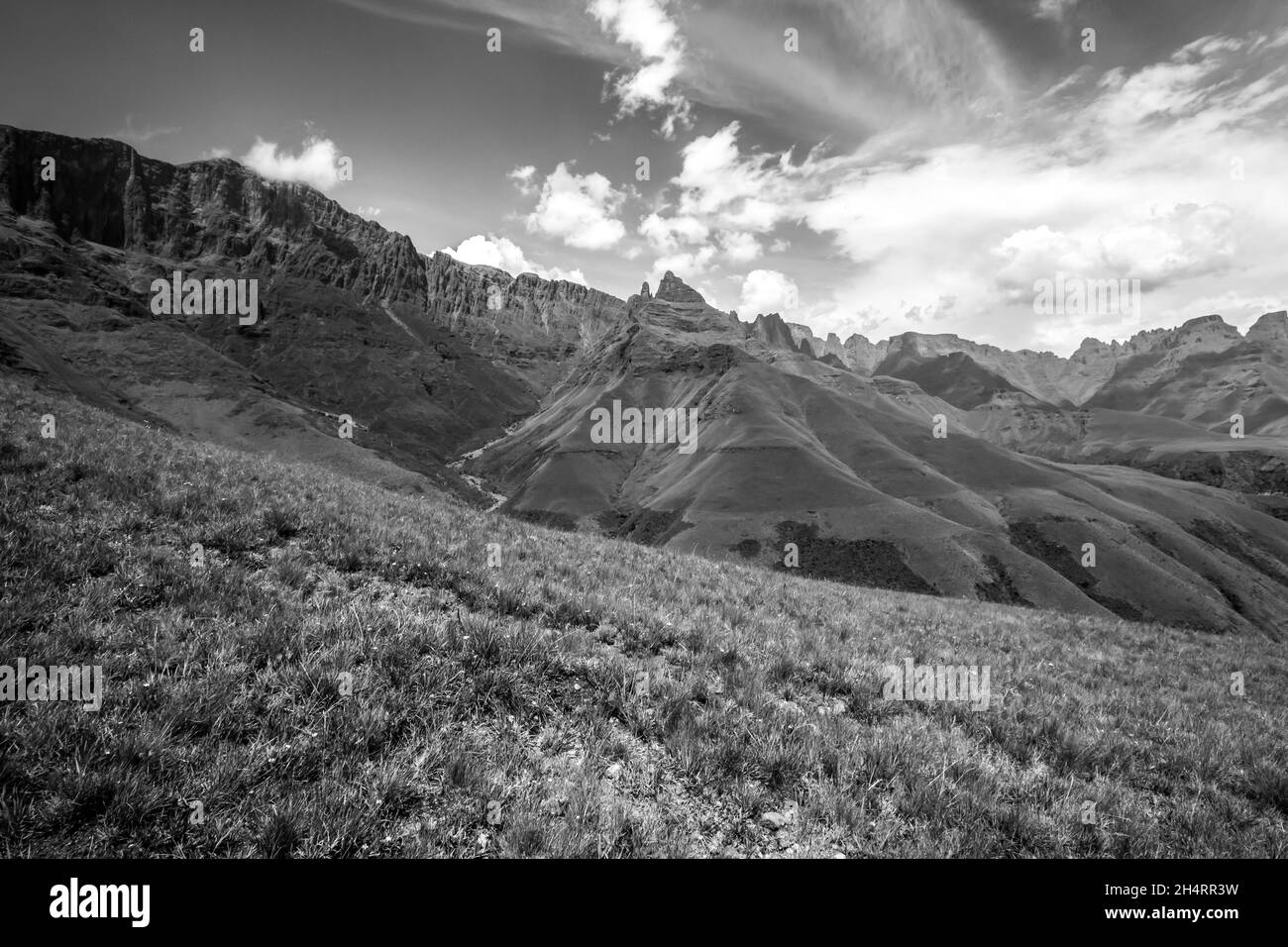 Si affaccia sulle ripide scogliere basaltiche e sulle cime affilate dei Monti Drakensberg, in Sud Africa, in bianco e nero. Le scogliere e le cime iconiche Foto Stock