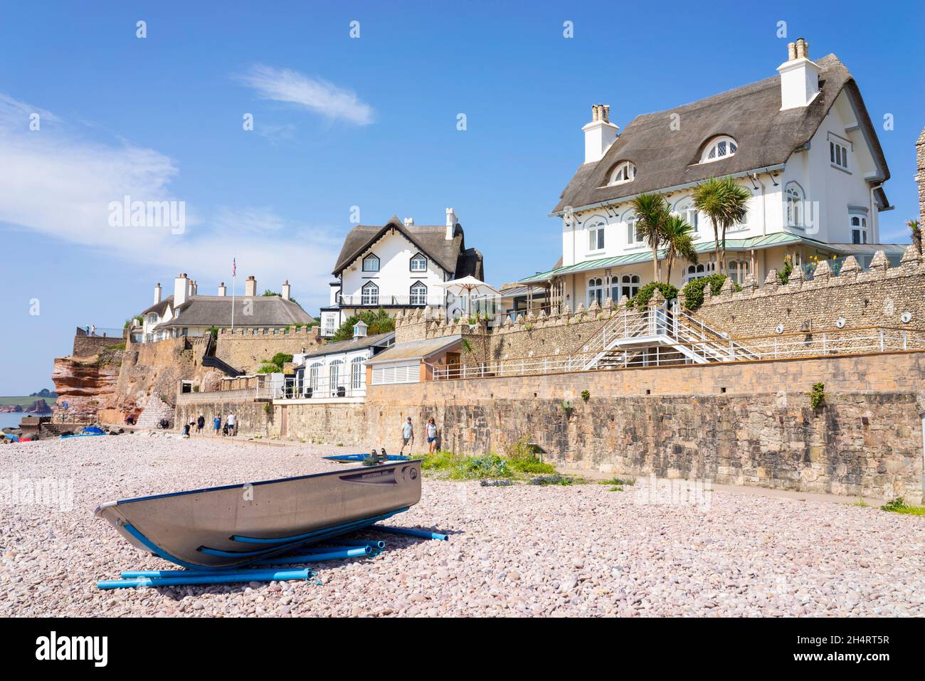 Sidmouth Devon Sidmouth Beach piccola barca sulla spiaggia di ciottoli sotto il Rock Cottage Hotel e il Beacon Sidmouth Town Sidmouth Devon Inghilterra Regno Unito GB Europa Foto Stock