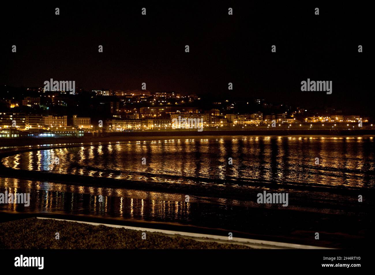 Un'immagine notturna del porto di San Sebastian al largo della baia di Biscaglia nel tumuntanious Paese Basco della Spagna Foto Stock