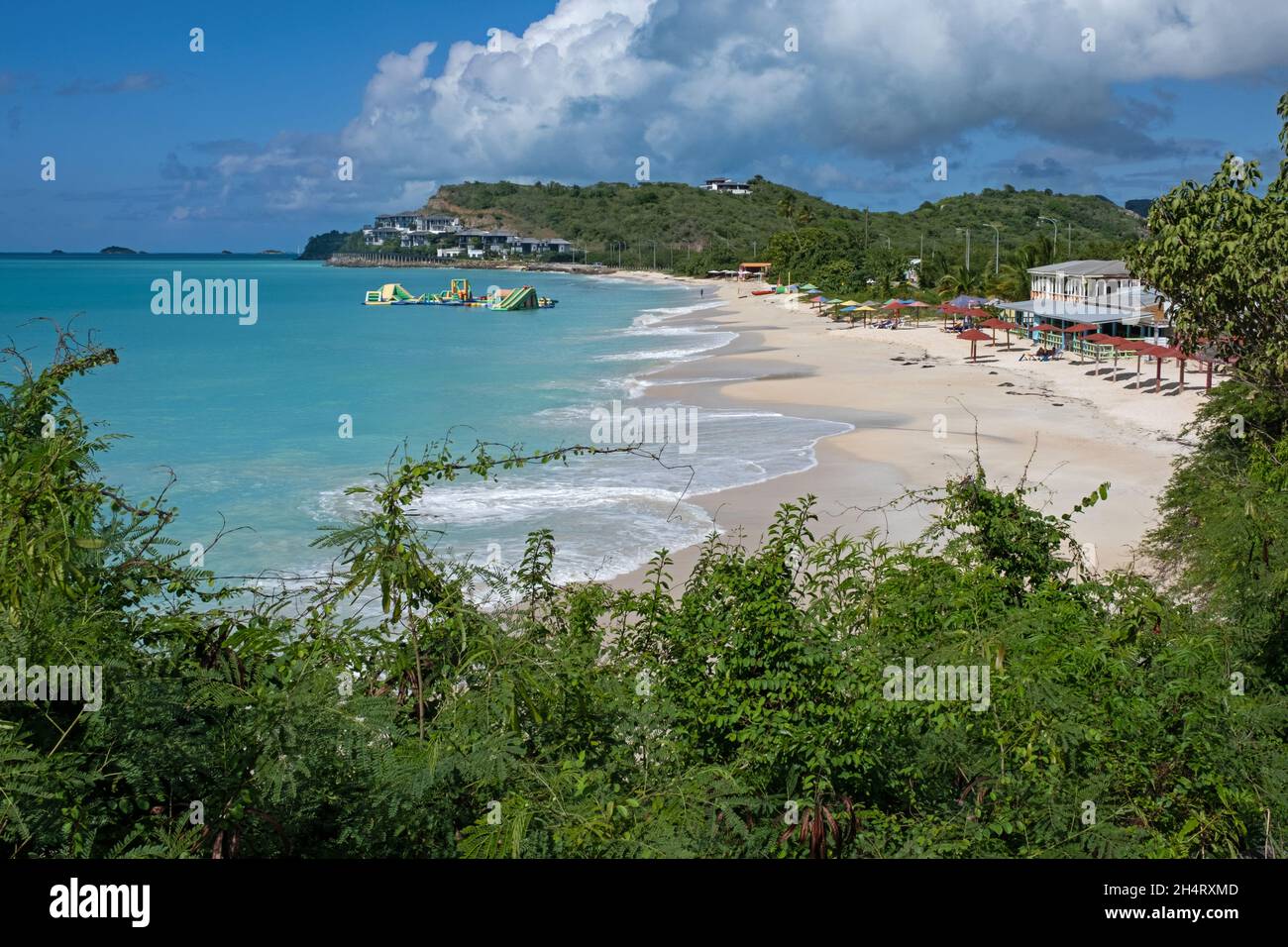 Spiaggia di sabbia bianca e acqua azzurra in località balneare lungo la costa occidentale dell'isola Antigua, piccole Antille nel Mar dei Caraibi Foto Stock
