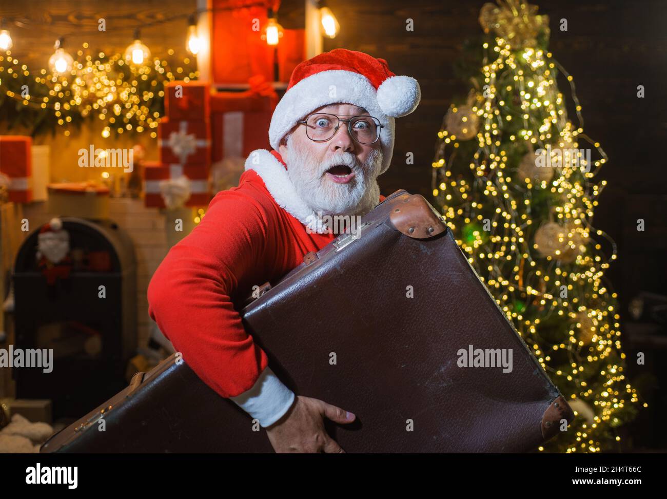 Babbo Natale con valigia da viaggio. Vacanze di Natale. Pubblicità di nuovo anno. Servizio di consegna. Concetto di viaggio. Foto Stock