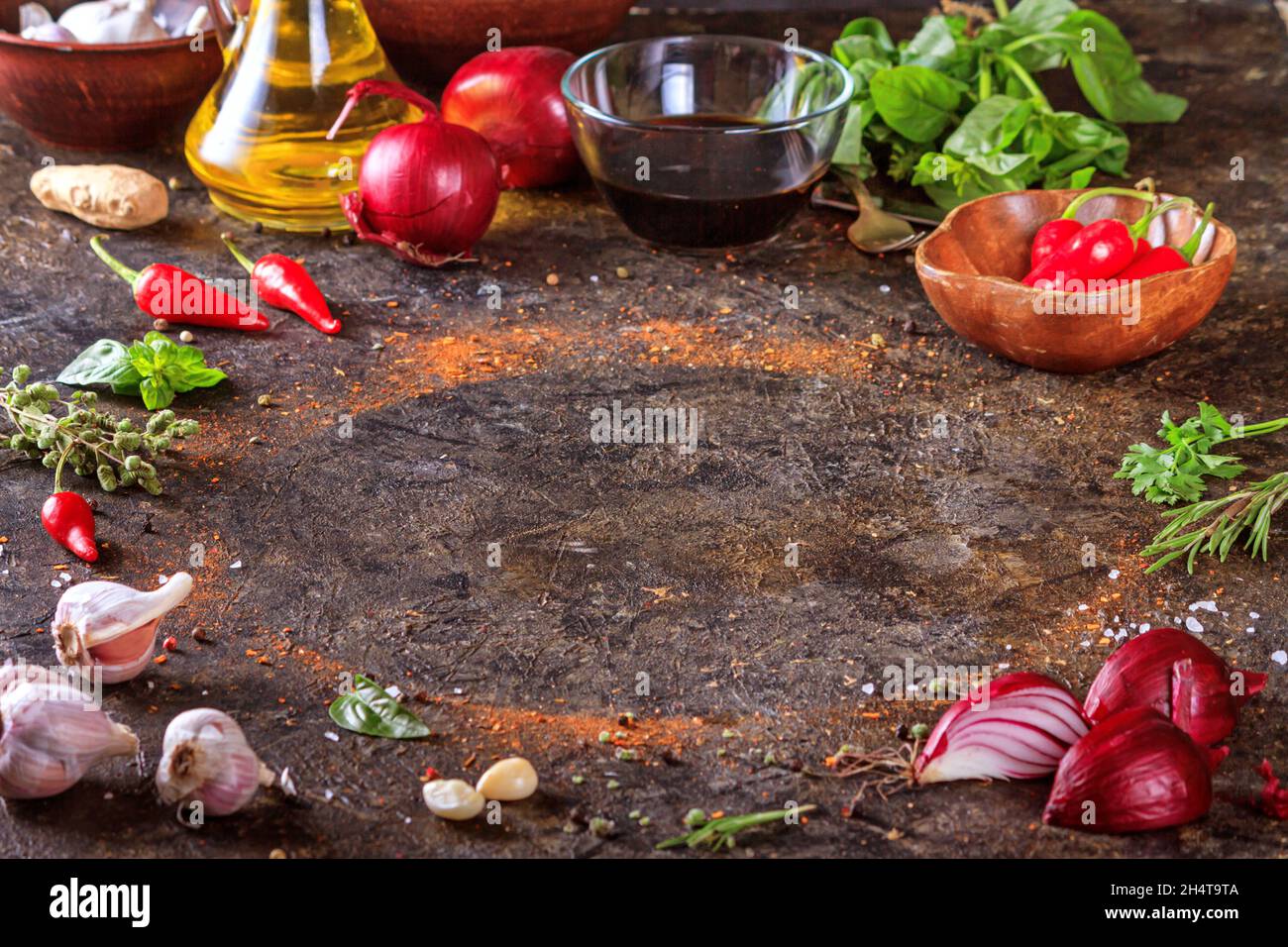 Sfondo culinario con superficie in pietra da cucina, olio d'oliva in una brocca e verdure. Spazio vuoto per menu o ricetta con messa a fuoco selettiva Foto Stock