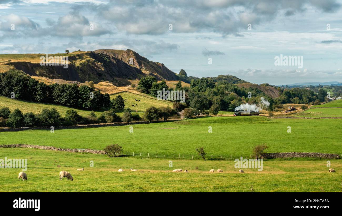 La ferrovia a vapore di Embsay & Bolton Abbey, con treno a vapore che viaggia vicino alla cava di Embsay con un pennacchio di fumo/vapore, lo Yorkshire Dales National Park, Regno Unito Foto Stock