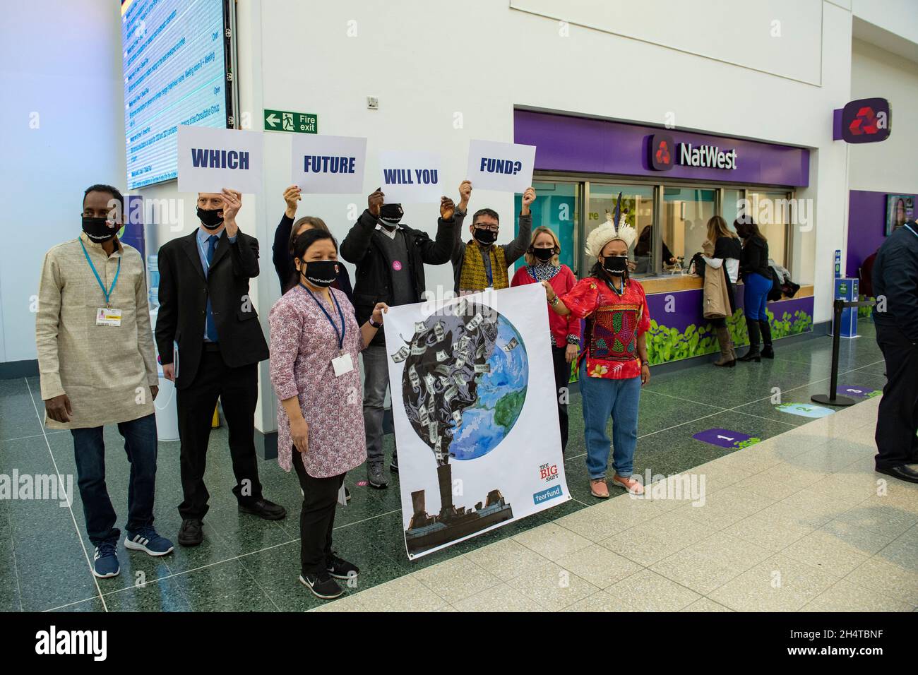 Glasgow, Scozia, Regno Unito. 4 novembre 2021. NELLA FOTO: Un gruppo di delegati della Conferenza sul cambiamento climatico COP26 è stato visto in una protesta al di fuori della NatWest Bank nell'edificio SECC del SEC Campus con i segnali che indicano "QUALE FUTURO FONDI?". Ciò avviene ieri, in cui la conferenza si è dedicata specificamente al fondo globale per il clima. Credit: Colin Fisher/Alamy Live News Foto Stock