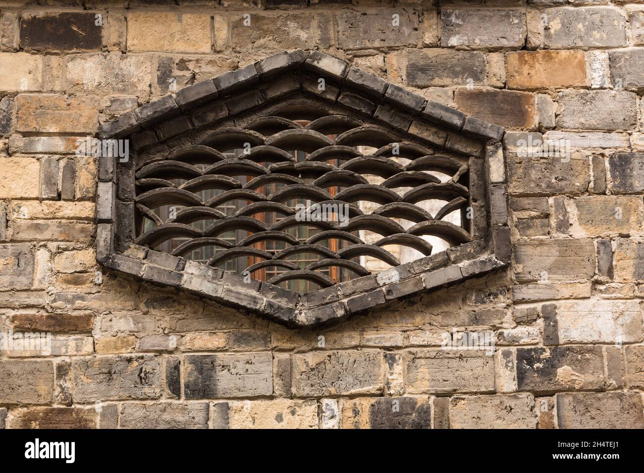 Un disegno in una finestra attraverso un muro di mattoni creato con piastrelle di argilla. Wuzhen, Cina. Foto Stock
