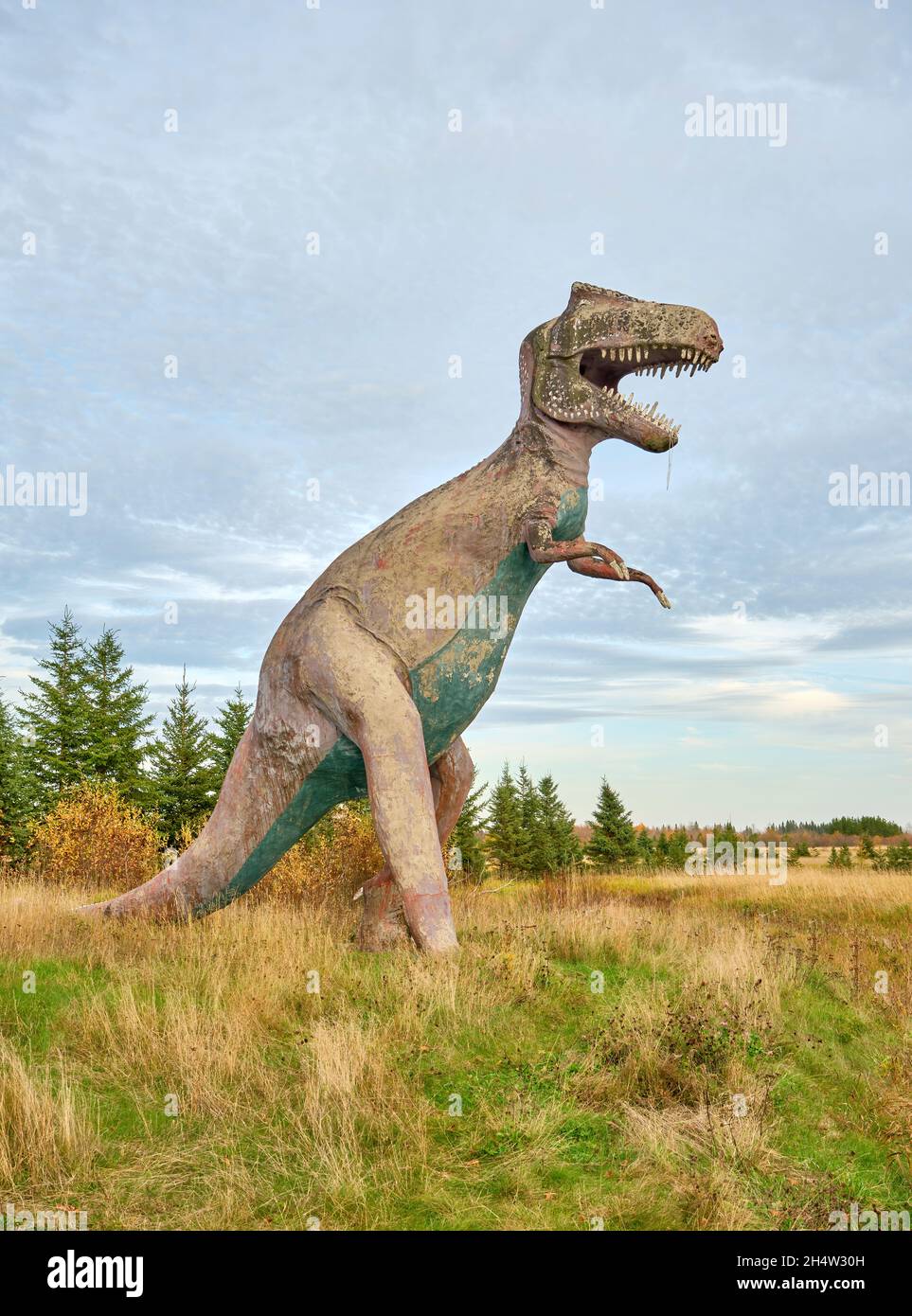Il dinosauro concreto sembra attraversare una radura lungo l'autostrada 11 nell'Ontario settentrionale. Foto Stock