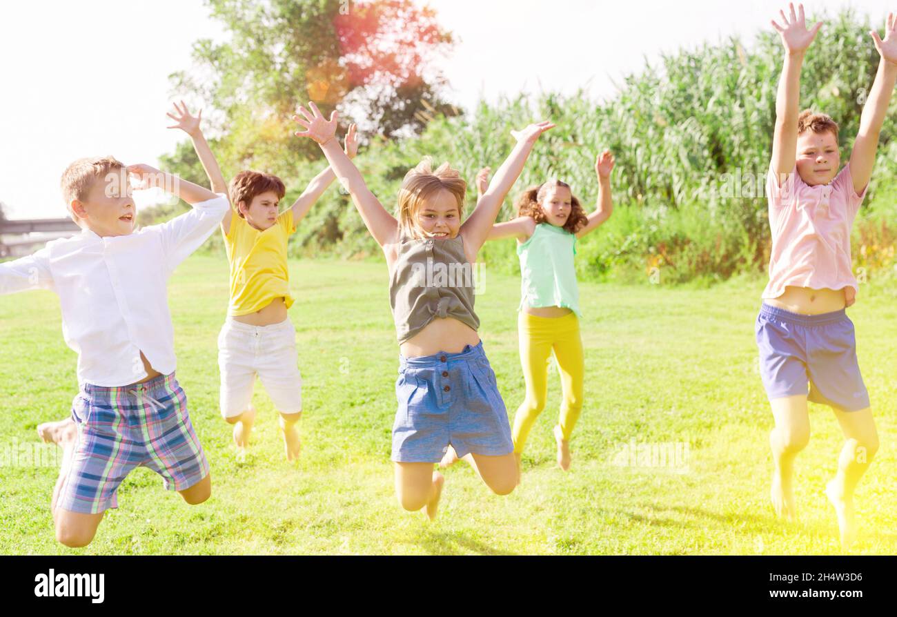 I bambini saltano e alzano le mani Foto Stock