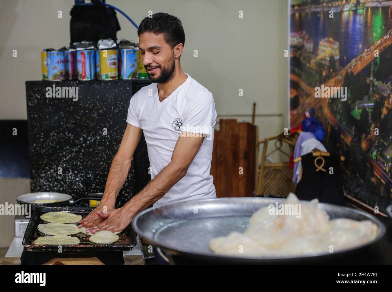 Gaza, Palestina. 4 novembre 2021. Il rifugiato palestinese Ahmed Ali prepara dolci Meshaltet nel campo profughi di al Shati, ad ovest di Gaza. I residenti del campo profughi di al-Shati, ad ovest di Gaza, si svegliano ogni giorno con l'odore di torte egiziane di 'meshaltet' che si diffondono in tutto il campo e nei suoi vicoli, preparati dal rifugiato Ahmed Ali. I residenti del campo sono entusiasti di mangiare la colazione da Ahmed Ali (32 anni), che si è specializzato solo in 'meshaltet'. (Foto di Mahmoud Issa/SOPA Images/Sipa USA) Credit: Sipa USA/Alamy Live News Foto Stock