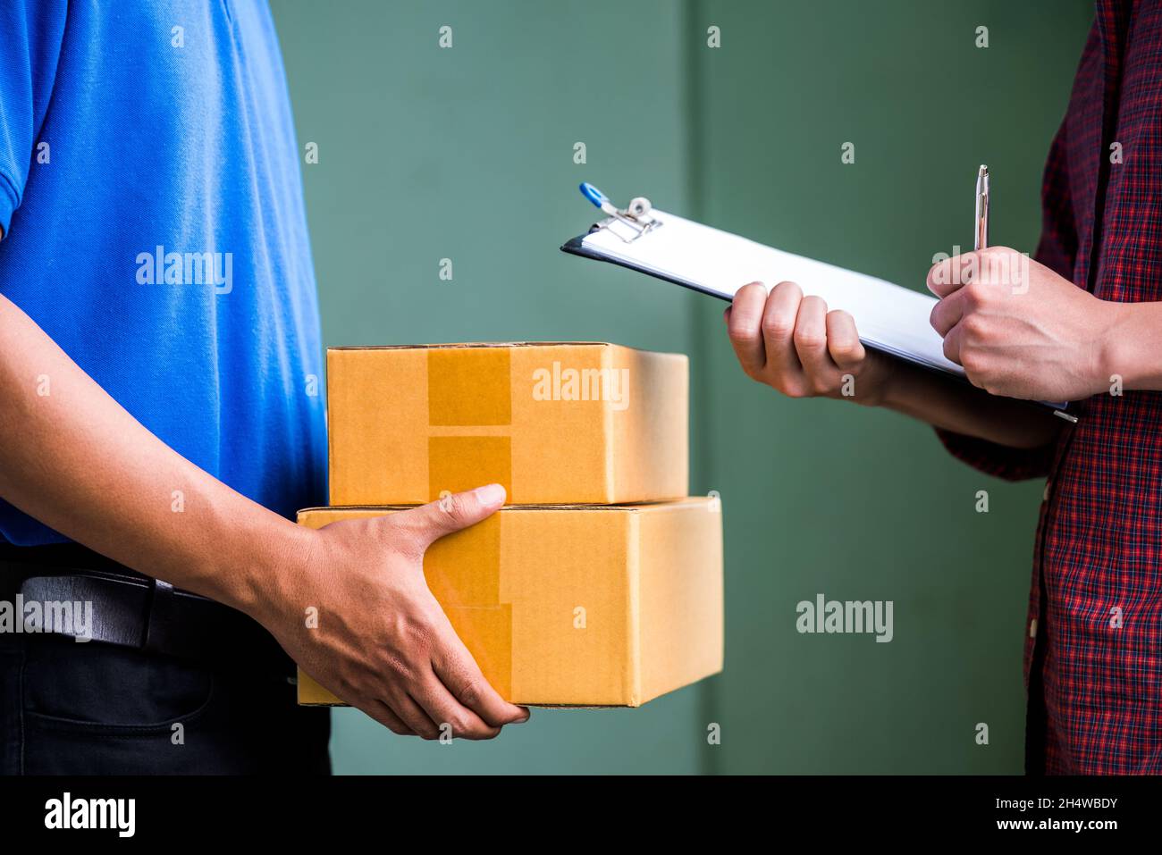 Primo piano le mani maschili firmando per ottenere il suo pacchetto da uomo di consegna. Foto Stock