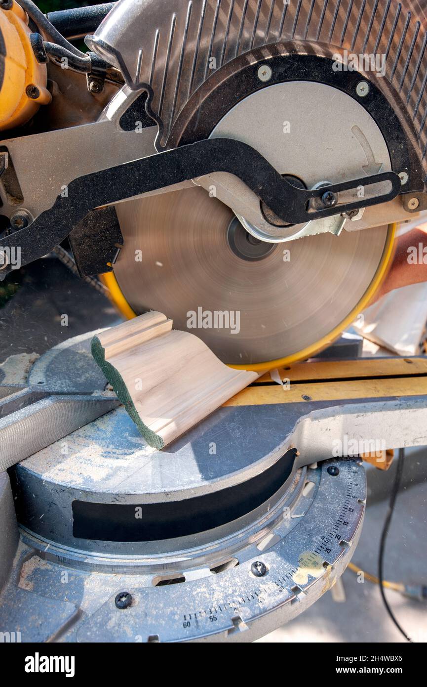 Rifinire il carpentiere utilizzando una sega a taglio obliquo composta per la modanatura della corona conica Foto Stock