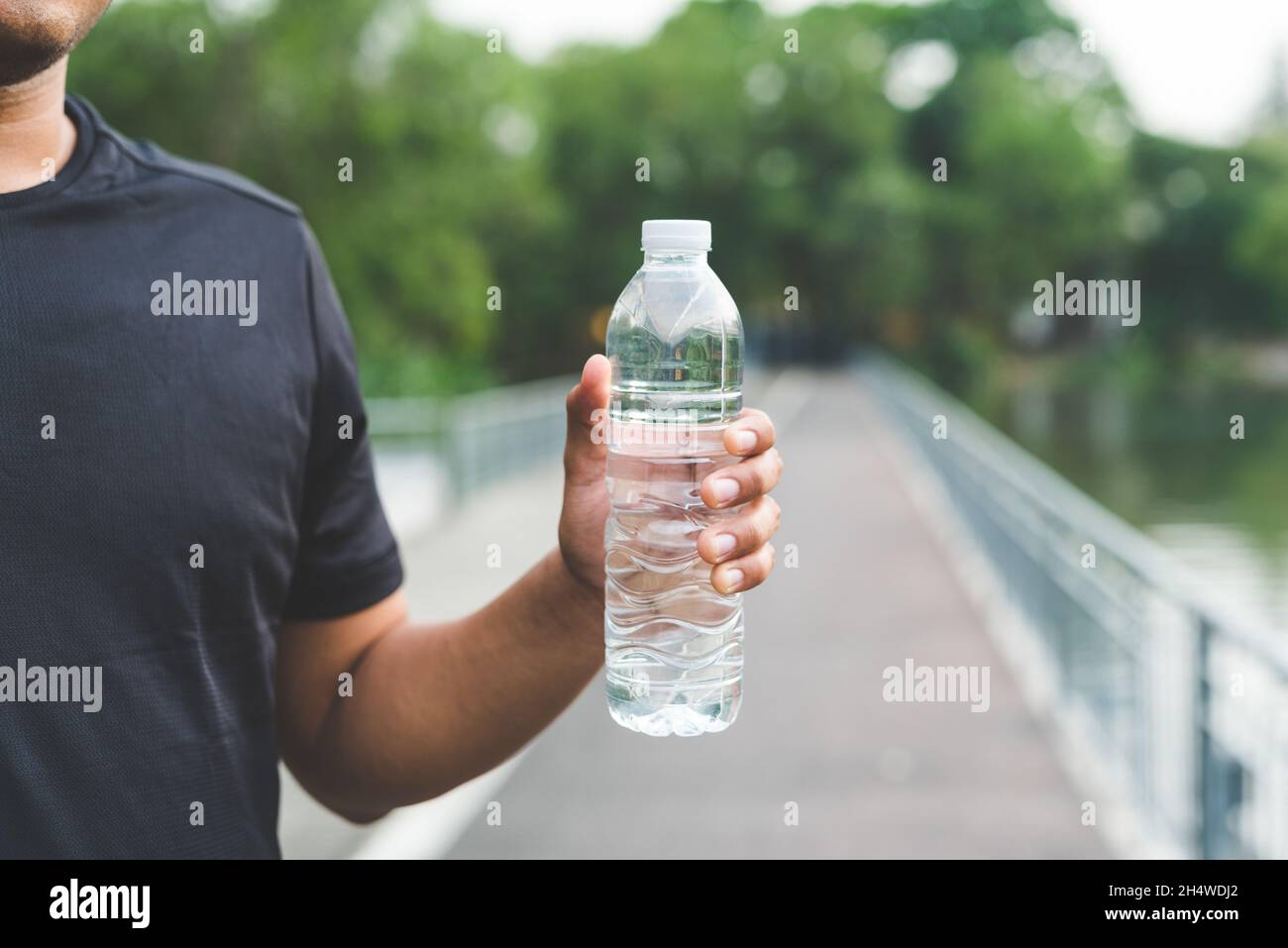 Giovane corridore del fitness che beve una bottiglia d'acqua. Foto Stock