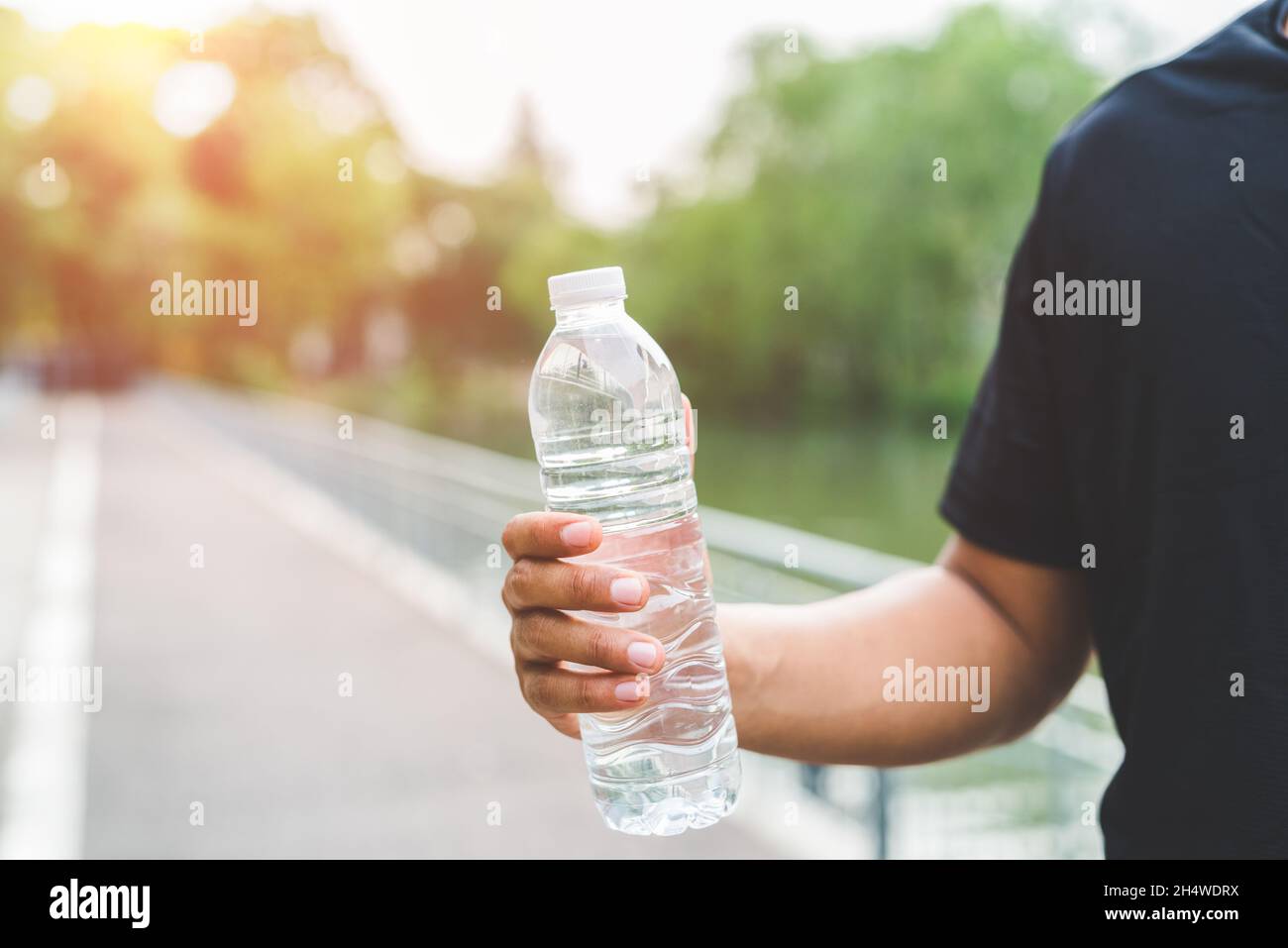Giovane corridore del fitness che beve una bottiglia d'acqua. Foto Stock