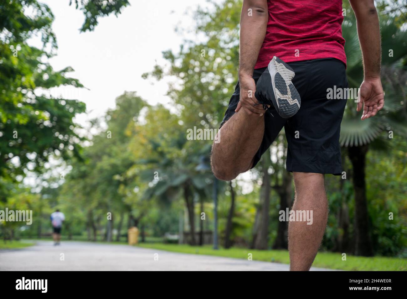 Giovane uomo di fitness runner stretching prima di correre sano stile di vita e. concetti sportivi Foto Stock