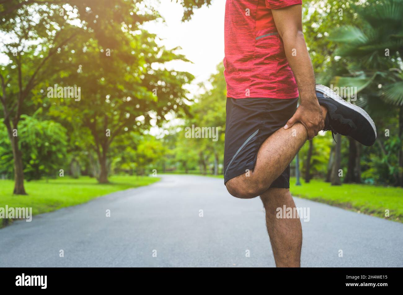 Giovane uomo di fitness runner stretching prima di correre sano stile di vita e. concetti sportivi Foto Stock