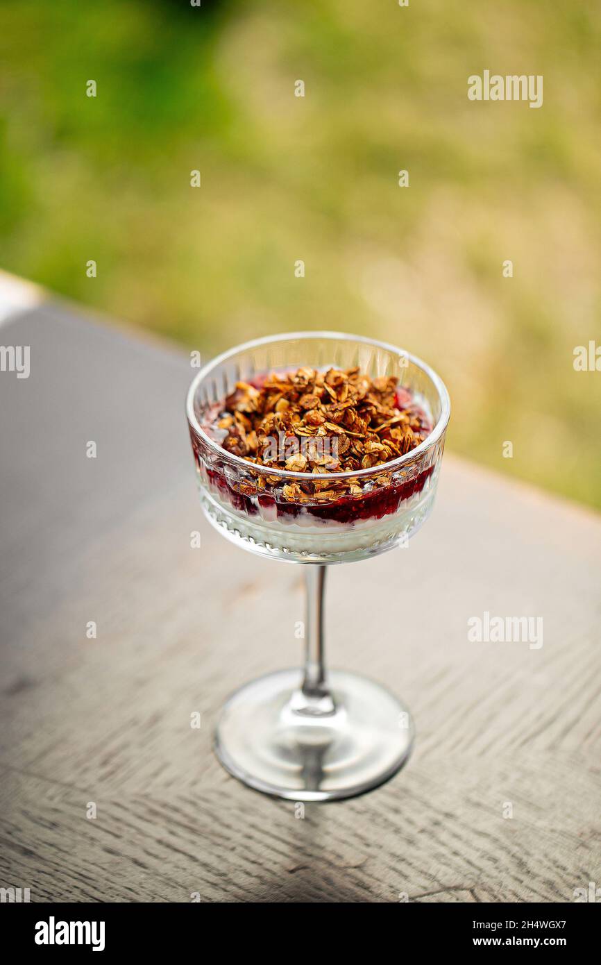 Dessert al trifle alla granola in un bicchiere di fantasia Foto Stock