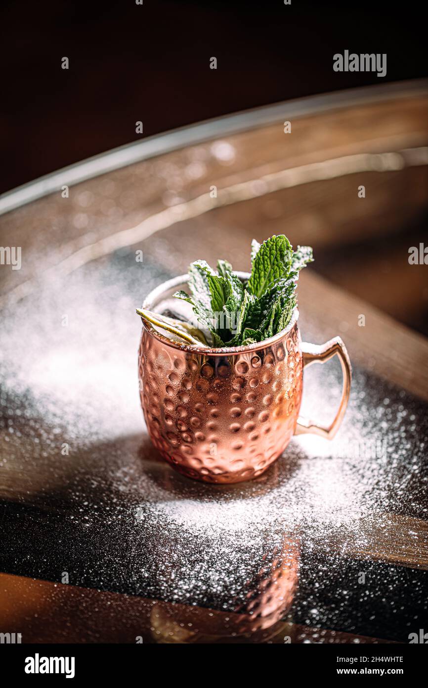 Tazza di rame di cocktail con menta e zucchero in polvere Foto Stock