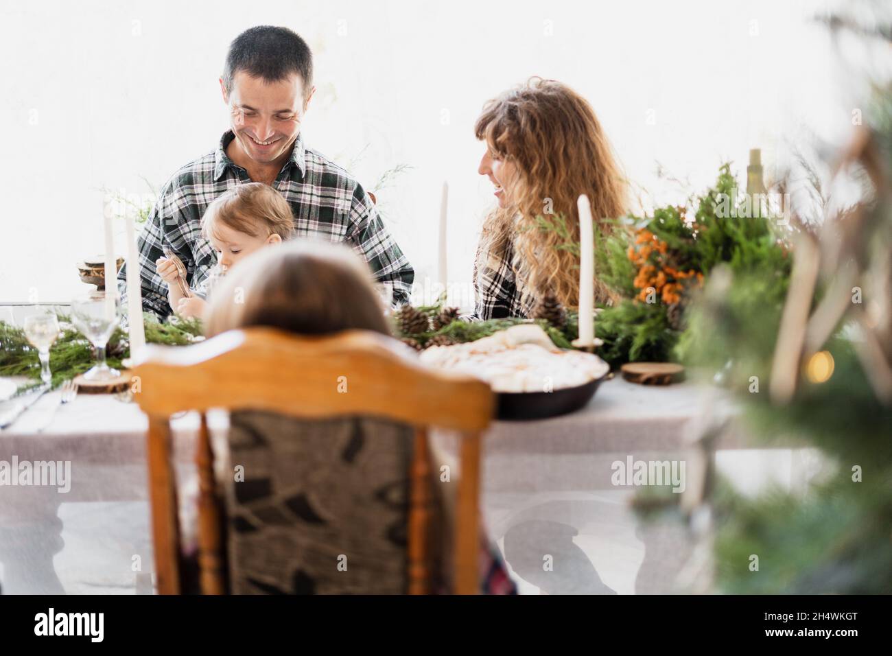 Una famiglia con un figlio giovane a cena di Natale. Prima colazione per Natale in un tavolo decorato. Buone relazioni familiari. Casa di Natale Foto Stock