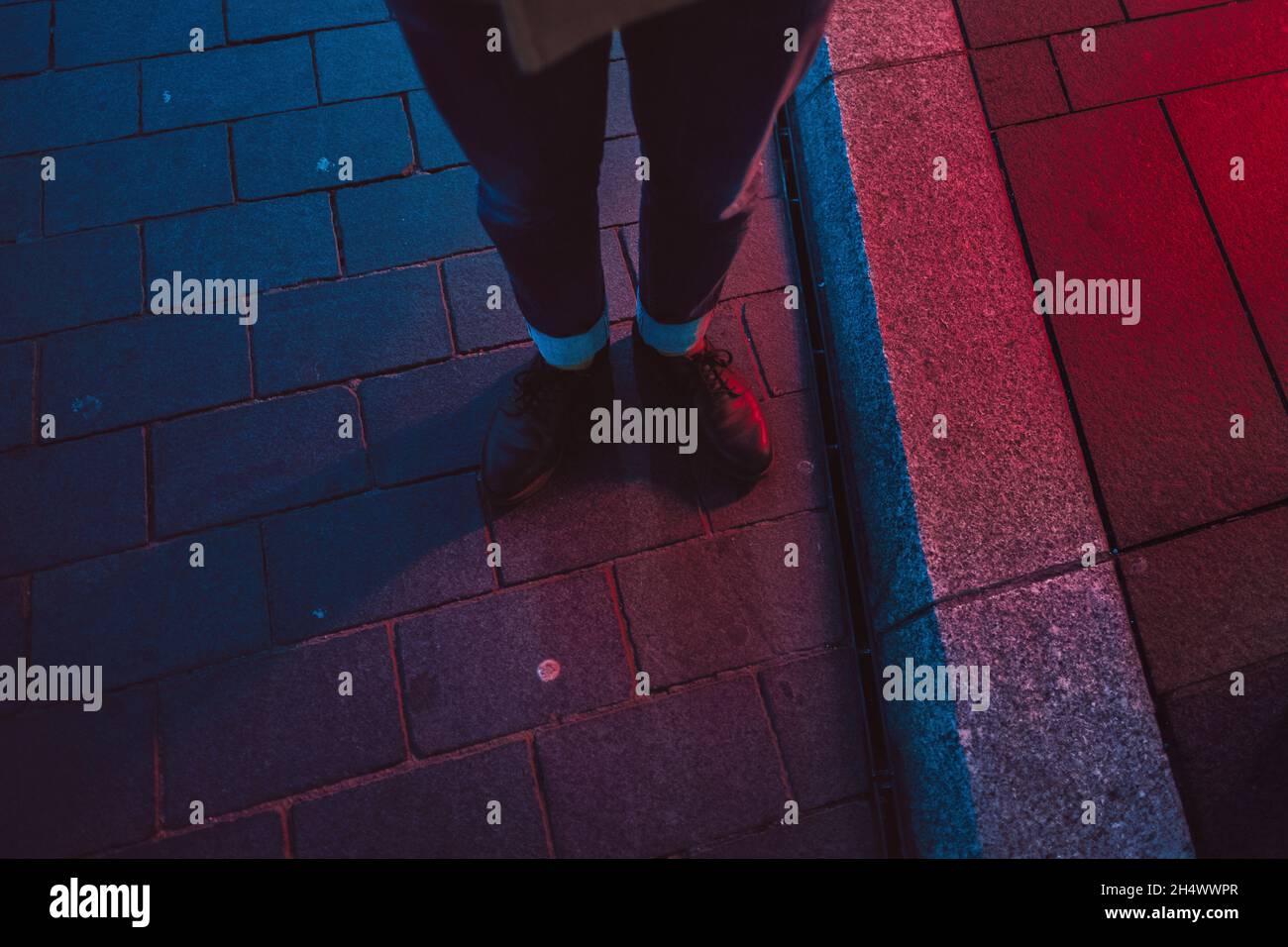 Gambe di Hipster in blu e rosso illuminazione impostazione di notte Foto Stock