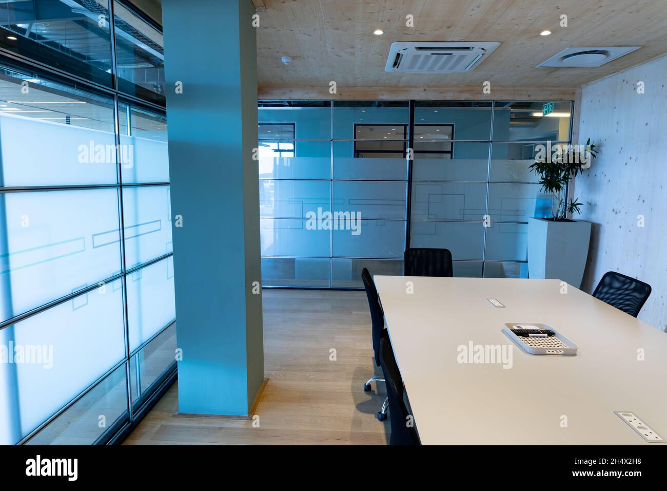 Moderna sala riunioni vuota con tavolo per conferenze e pareti in vetro in ufficio Foto Stock