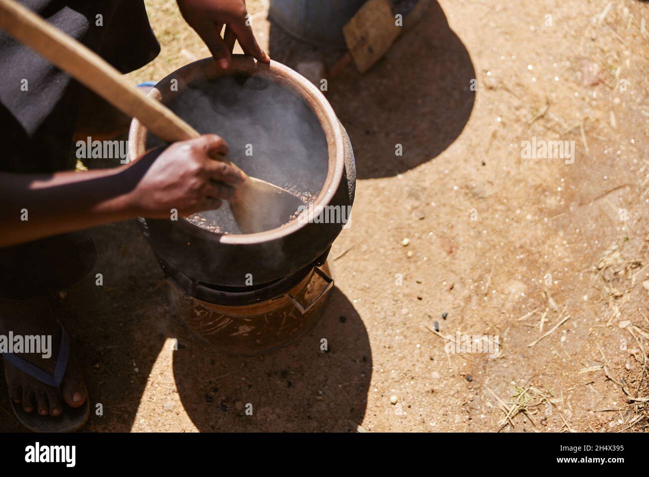 Processo tradizionale africano di torrefazione del caffè da parte di tribù locali nelle regioni di montagna Foto Stock