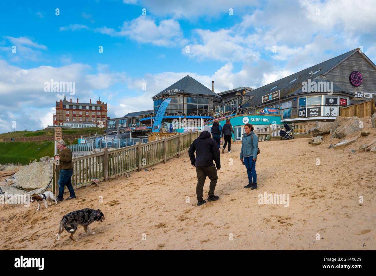 La gente ed i loro cani che camminano sulla spiaggia di Fistral a Newquay in Cornovaglia Foto Stock