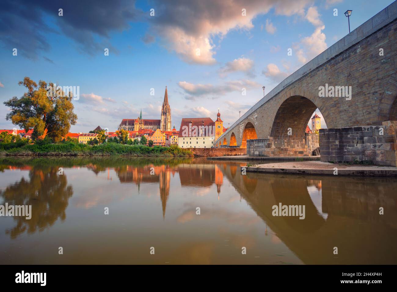 Regensburg, Germania. Immagine del paesaggio urbano di Ratisbona, Germania con il Ponte Vecchio di pietra sul Danubio e la Cattedrale di San Pietro al tramonto estivo. Foto Stock