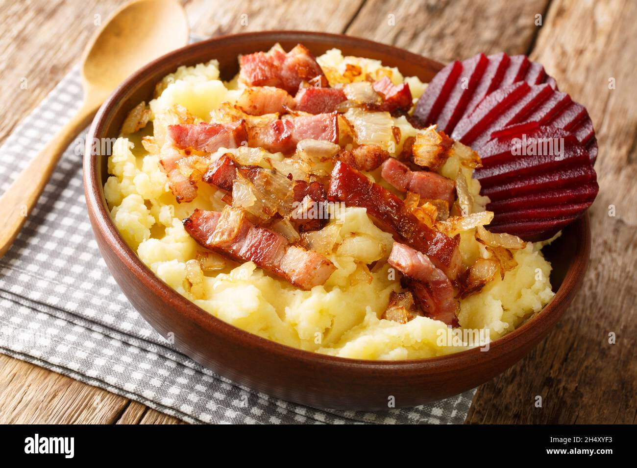 Purè di patate con pancetta croccante e cipolle fritte in una ciotola sul tavolo. Orizzontale Foto Stock