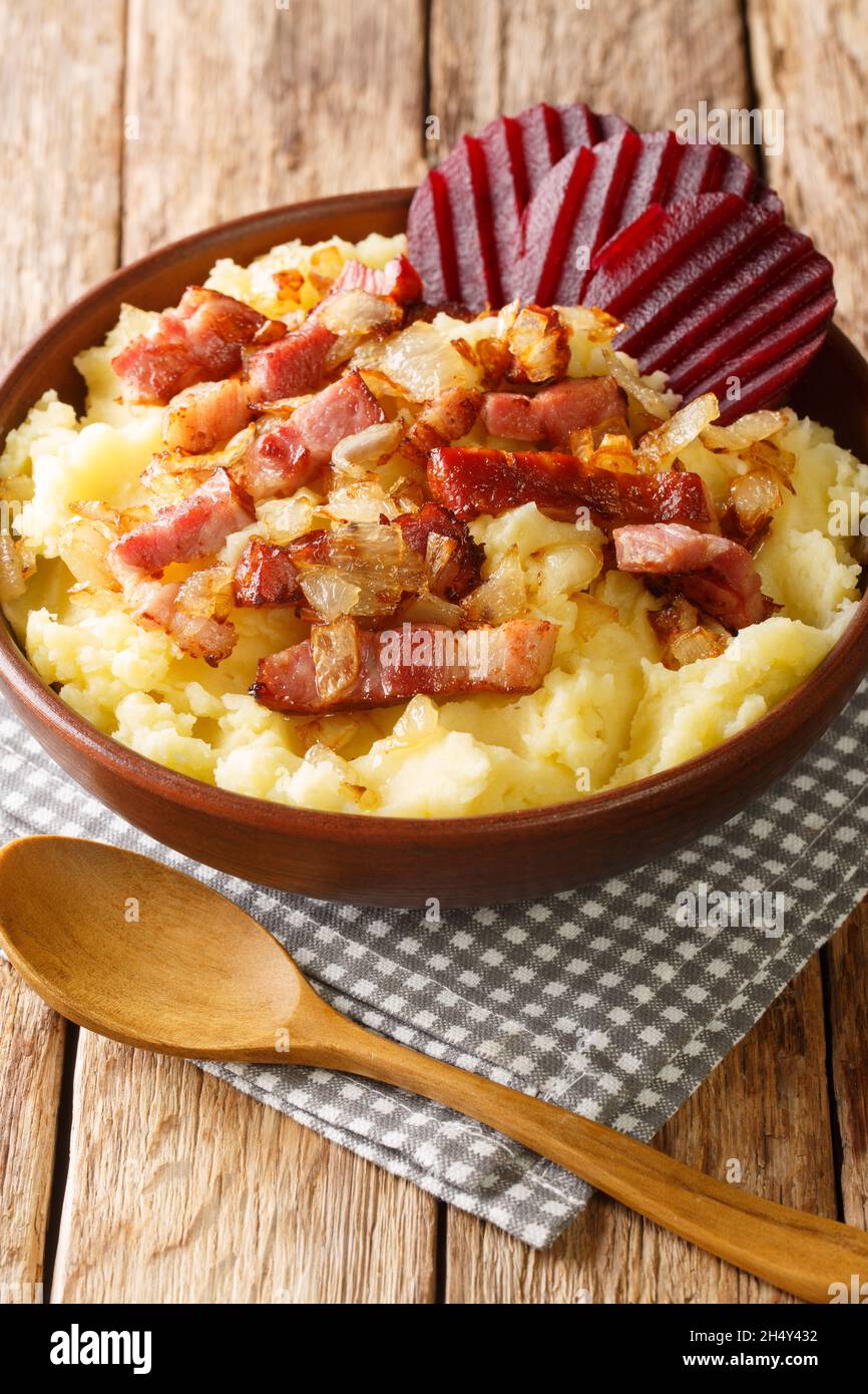 Braendende Kaerlighed o Burning Love è un vecchio piatto danese con purè di patate, croccanti fette di bacon e cipolle fritte in un primo piano in una ciotola sulla linguetta Foto Stock