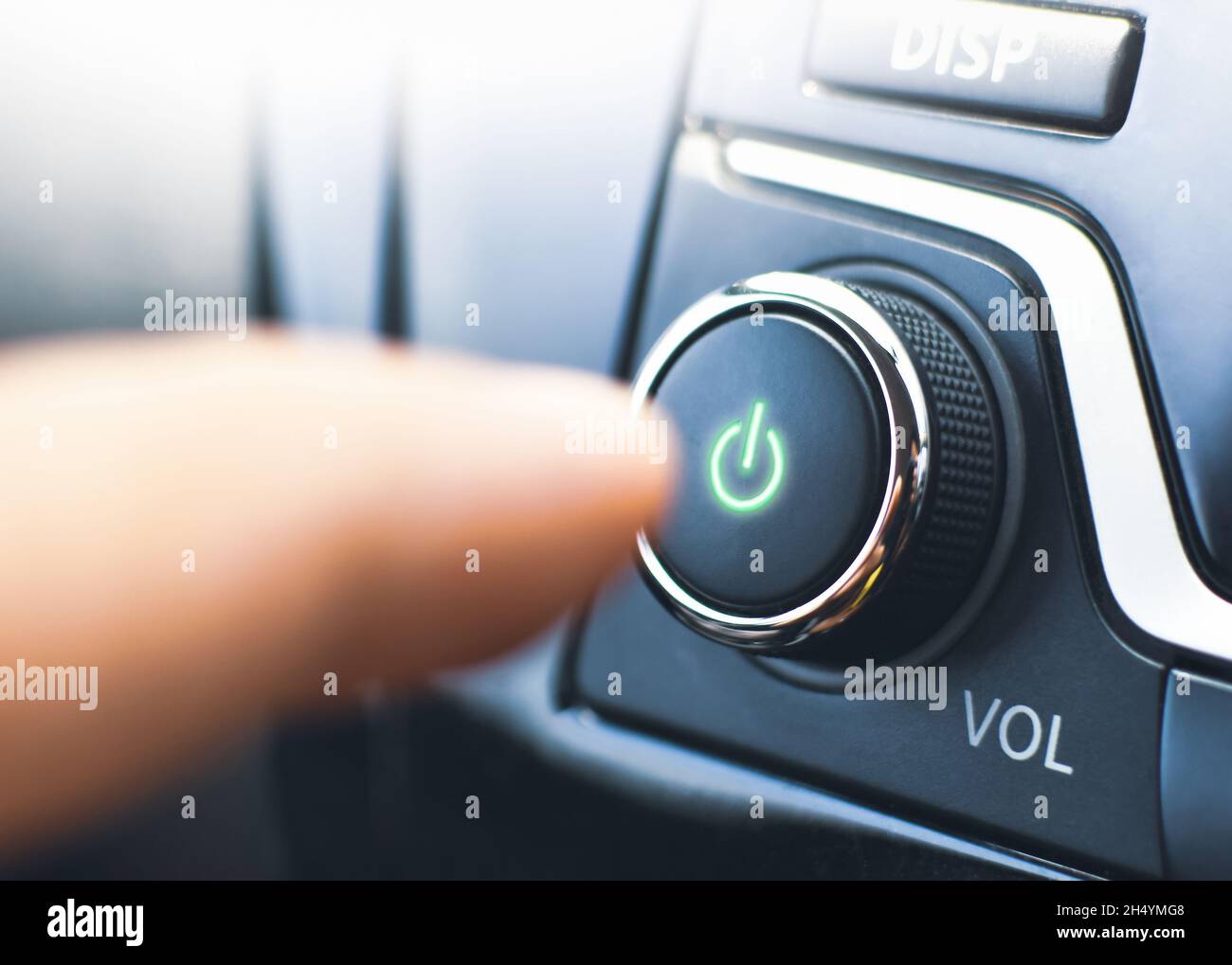 Il conducente preme il pulsante di accensione del lettore audio nell'automobile Foto Stock