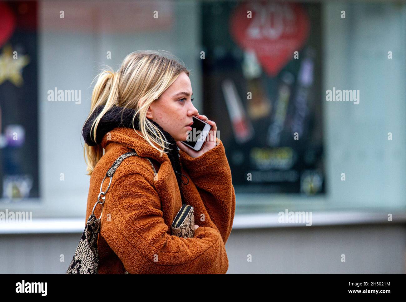 Dundee, Tayside, Scozia, Regno Unito. 5 novembre 2021. UK Meteo: Fresco clima di novembre in tutta la Scozia nord-orientale con temperature che raggiungono i 12°C. Una giovane donna attraente sta parlando sul suo telefono cellulare mentre trascorre la giornata fuori godendo il tempo d'autunno nel centro di Dundee. Credit: Dundee Photographics/Alamy Live News Foto Stock