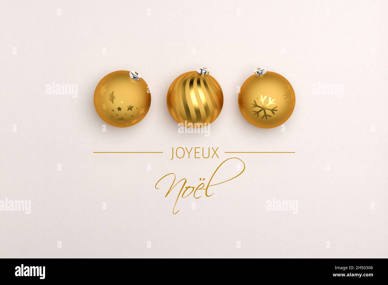Tre baubles dorati di natale su sfondo cartaceo. Messaggio francese "Joyeux Noël" (buon Natale) qui sotto. Foto Stock