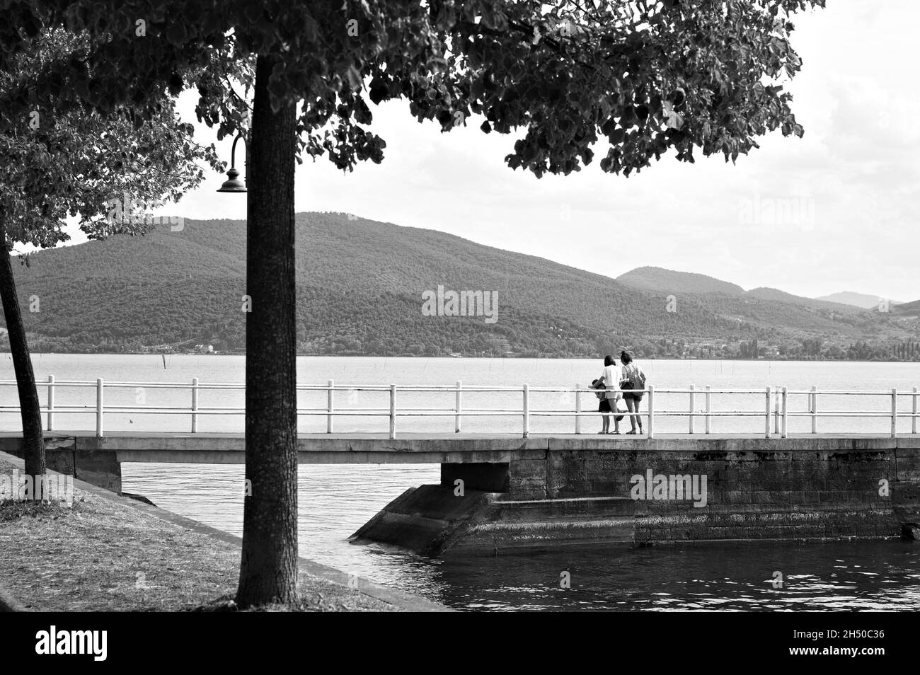 Una famiglia sul molo del lago Trasimeno in una giornata estiva (Umbria, Italia, Europa) Foto Stock